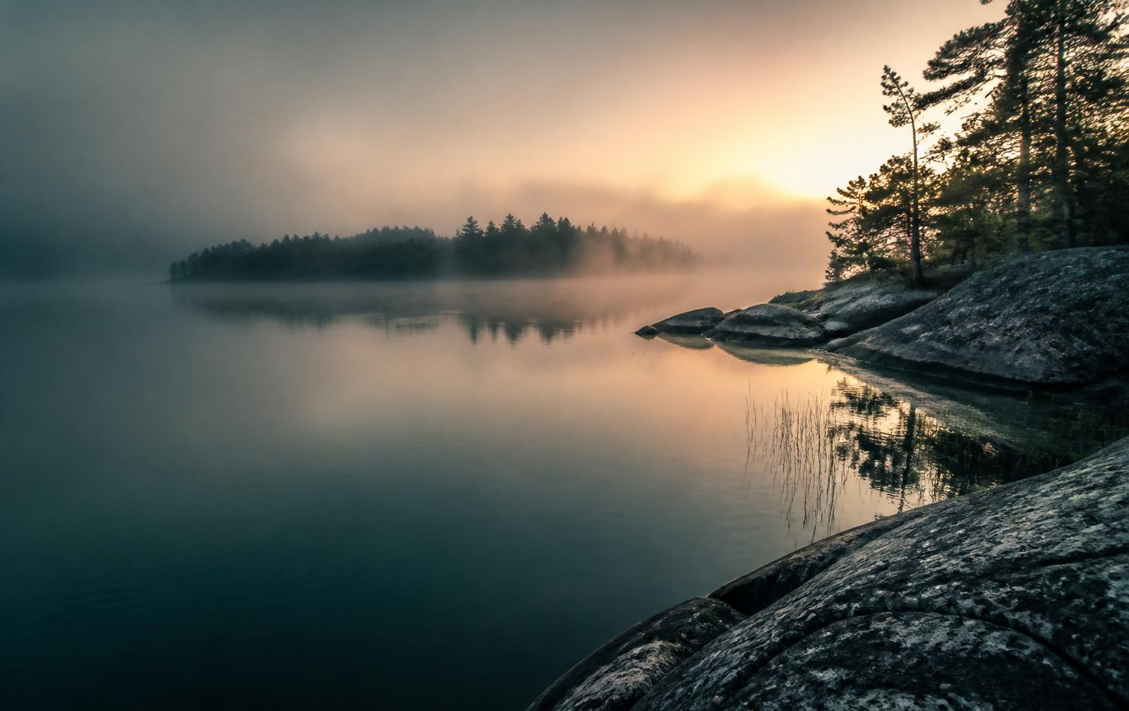 Misty sunrise over a Canadian lake